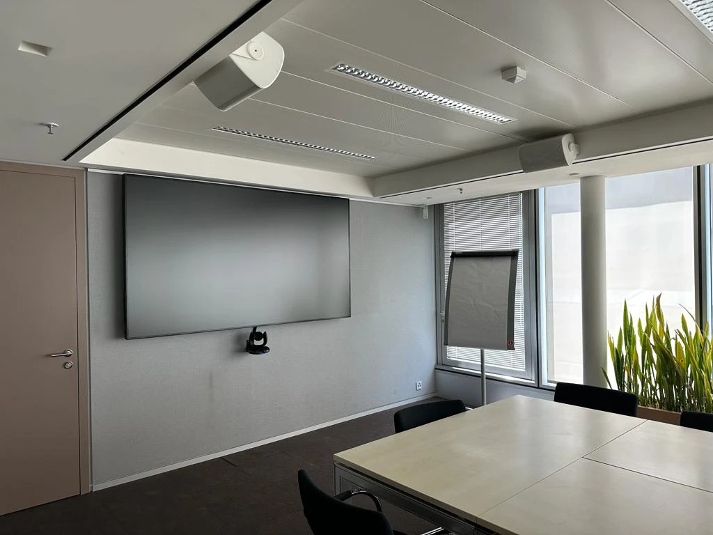 Modern conference room with wall-mounted display and city views